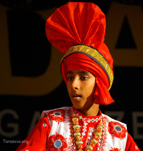 Молодой исполнитель в красочном костюме Молодой исполнитель в красочном костюме