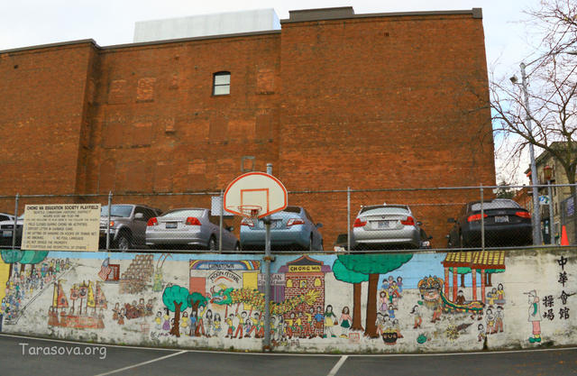 Спортивная площадка с рисунками на стене, показывающие историю иммиграции китайцев Спортивная площадка с рисунками на стене, показывающие историю иммиграции китайцев