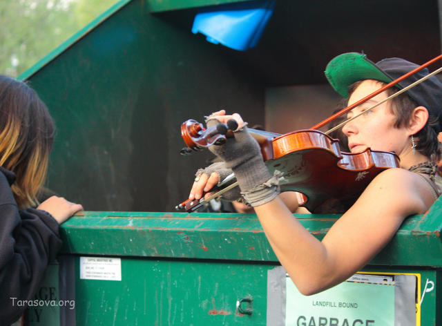 Любопытный зритель заглядывает в мусорный бак Любопытный зритель заглядывает в мусорный бак